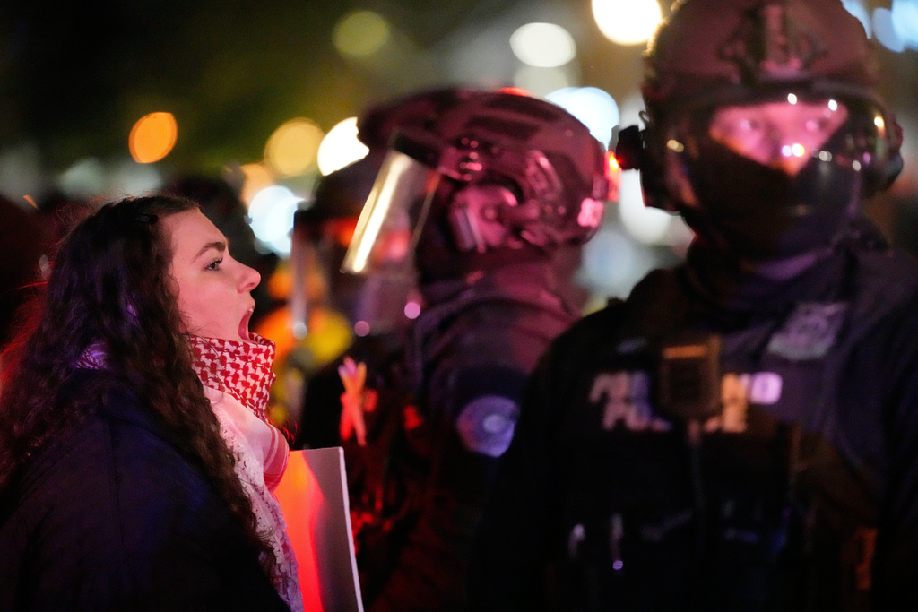 Una manifestante grita a un agente de la policía de Portland en el exterior de un edificio de ICE, el 8 de enero de 2026, en Portland, Oregon. (AP Foto/Jenny Kane)