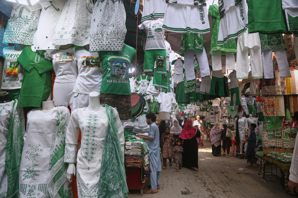 People visit a market to buy clothes specially prepared in national colors for the Pakistan's Independence Day celebrations, in Peshawar, Pakistan, Thursday, Aug. 13, 2026. (AP Photo/Muhammad Sajjad)