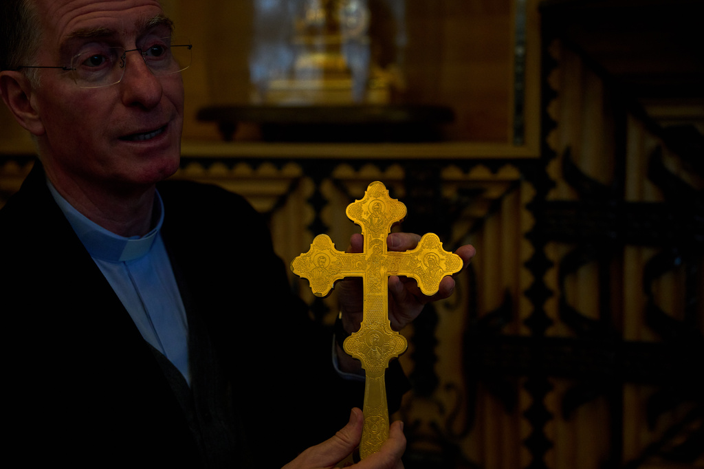 Josep Maria Turull, rector of the Basilica of the Sagrada Familia, holds a cross-shaped relic beside cabinets containing some of the basilica's most precious relics and liturgical vestments in Barcelona, May 15, 2026. (AP Photo/Emilio Morenatti)