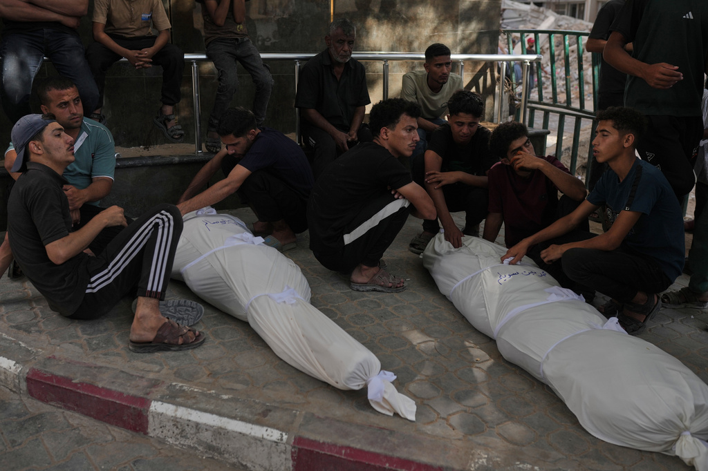 Mourners gather around the bodies of Palestinians killed in an Israeli strike, during their funeral in Shifa Hospital in Gaza City, Sunday, June 14, 2026. (AP Photo/Jehad Alshrafi)