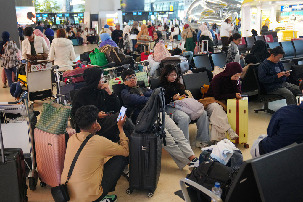 People wait as flights are disrupted due to the eruption of Mount Anak Krakatau, at Soekarno-Hatta International Airport in Tangerang, Indonesia, Monday, Sept. 7, 2026. (AP Photo/Tatan Syuflana)