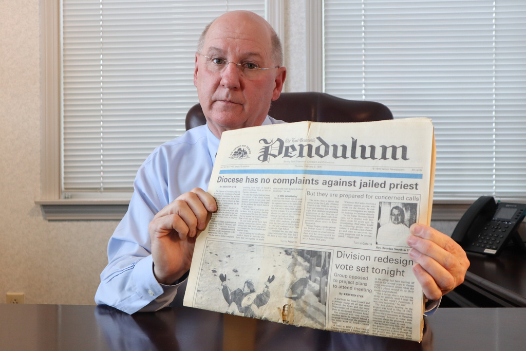 Dr. Herbert "Hub" Brennan, a clergy abuse survivor, displays a 1995 newspaper showing a headline that reads "Diocese has no complaints about jailed priest" at his internal medicine office in East Greenwich, R.I., Thursday, March 5, 2026. (AP Photo/Leah Willingham)