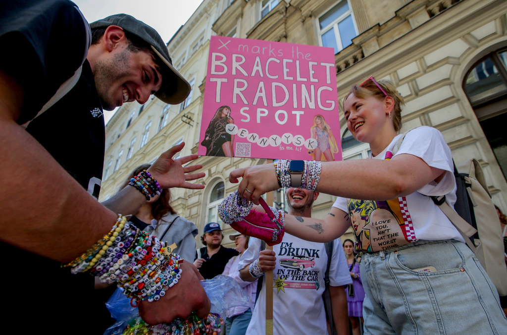 FILE - Fans of Taylor Swift also known as Swifties trade bracelets in the city centre in Vienna, Aug. 8, 2024. (AP Photo/Heinz-Peter Bader, File)