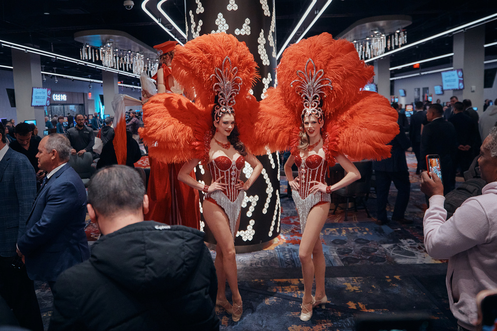 Showgirls in feathered costumes pose for photos during the opening of a casino floor at Resorts World New York City on Tuesday, April 28, 2026, in New York. (AP Photo/Andres Kudacki)