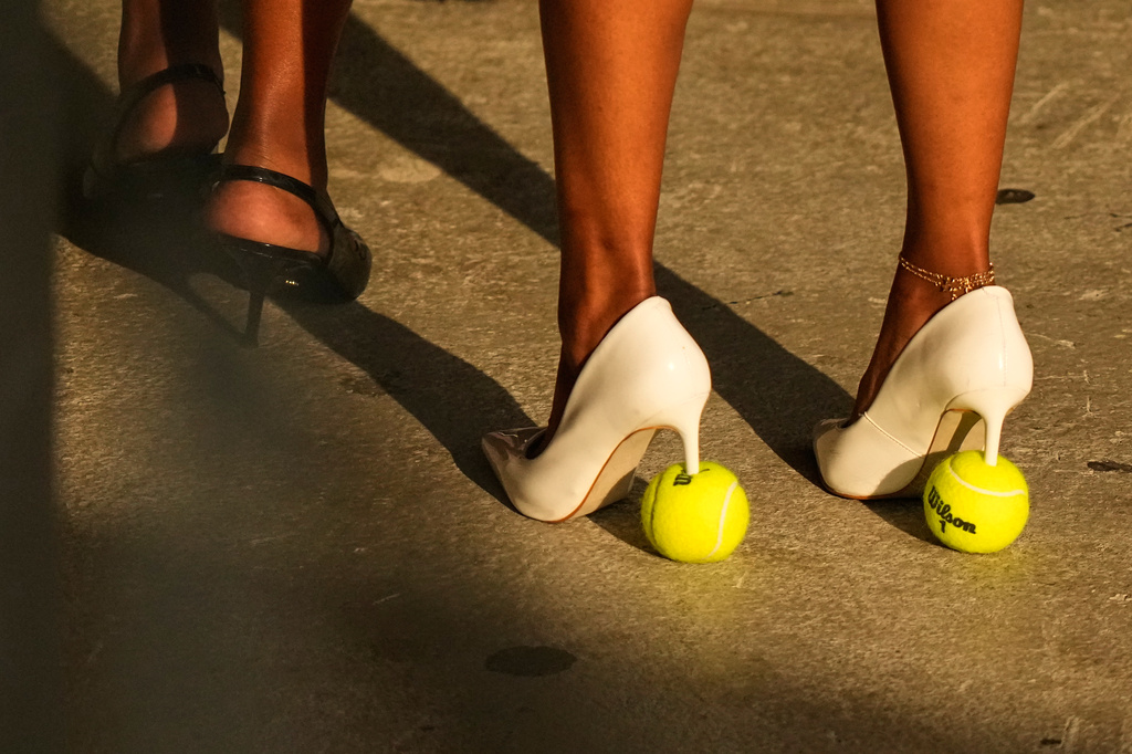 A woman wears tennis ball high heeled shoes during a match between Aryna Sabalenka, of Belarus, and Elena Rybakina, of Kazakhstan, during the women's singles final of the U.S. Open tennis championships Saturday, Sept. 12, 2026, in New York. (AP Photo/Frank Franklin II)