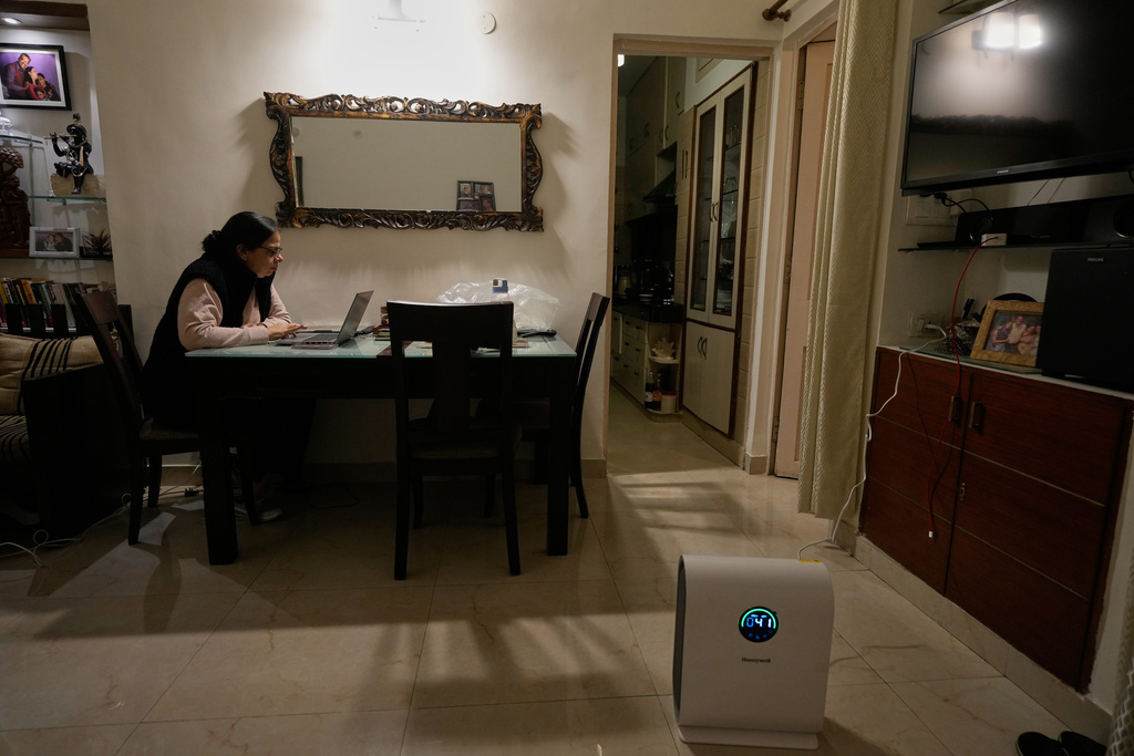 Renuka Jasra, 54, uses an air purifier while working from home in New Delhi, India, Tuesday, Nov. 18, 2025. (AP Photo/Manish Swarup)
