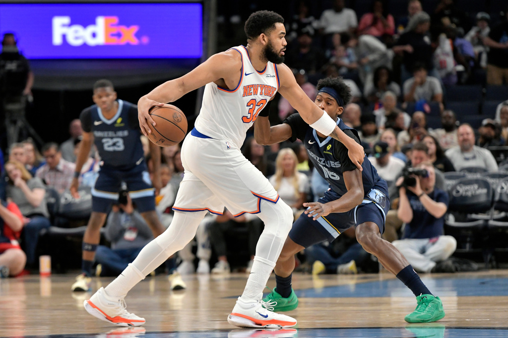 New York Knicks center Karl-Anthony Towns (32) handles the ball against Memphis Grizzlies forward Olivier-Maxence Prosper (18) in the first half of an NBA basketball game Wednesday, April 1, 2026, in Memphis, Tenn. (AP Photo/Brandon Dill)