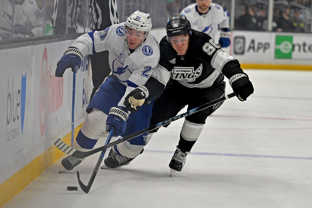 Tampa Bay Lightning center Brayden Point (21) and Los Angeles Kings left wing Andrei Kuzmenko battle along the boards for the puck during the first period of an NHL hockey game Thursday, Jan. 1, 2026, in Los Angeles. (AP Photo/Jayne Kamin-Oncea)