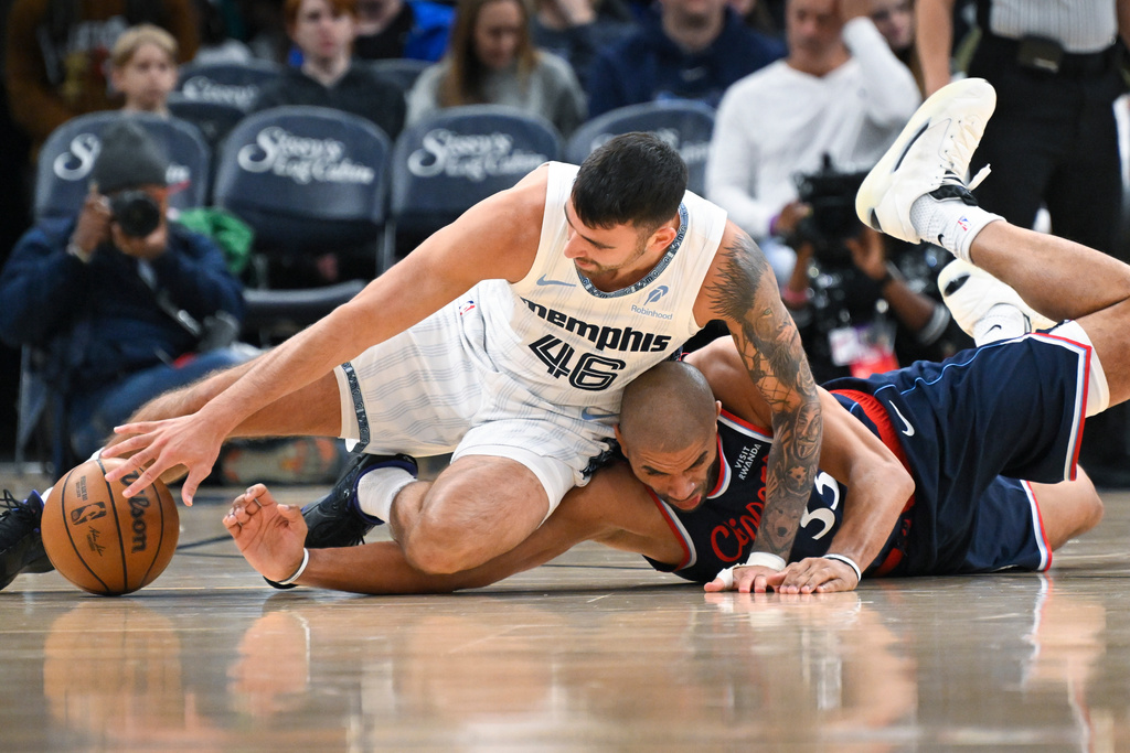Memphis Grizzlies guard John Konchar (46) and Los Angeles Clippers' Nicolas Batum (33) vie for a loose ball during the first half of an NBA basketball game Friday, Dec. 5, 2025, in Memphis, Tenn. (AP Photo/John Amis)