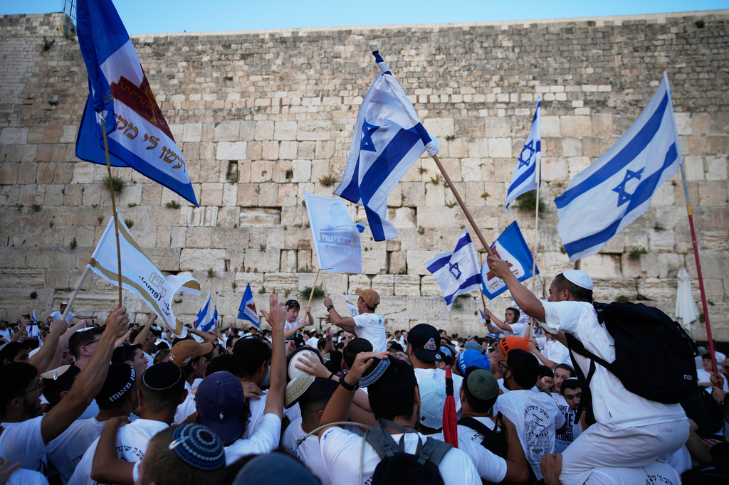 Israelis wave national flags during a march marking Jerusalem Day, an Israeli holiday celebrating the capture of east Jerusalem in the 1967 Mideast war, next to the Western Wall in the Old City of Jerusalem , Thursday, May 14, 2026. (AP Photo/Ohad Zwigenberg)
