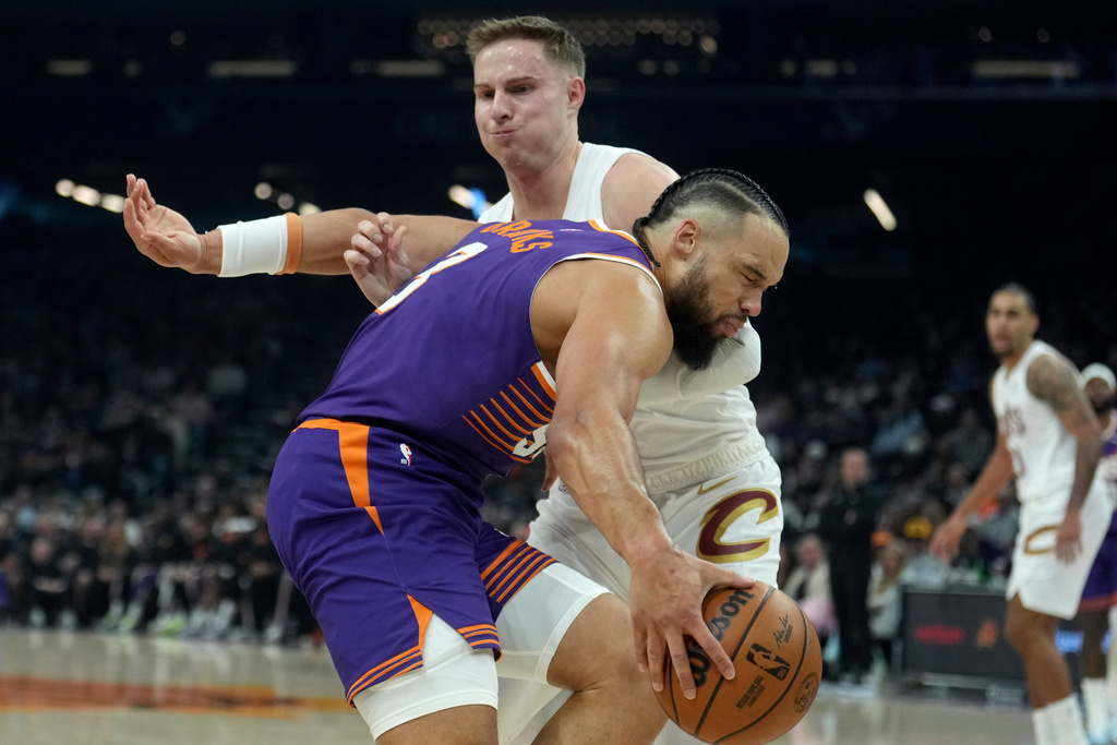 Phoenix Suns forward Dillon Brooks, right, is fouled by Cleveland Cavaliers guard Sam Merrill during the first half of an NBA basketball game Friday, Jan. 30, 2026, in Phoenix. (AP Photo/Ross D. Franklin)