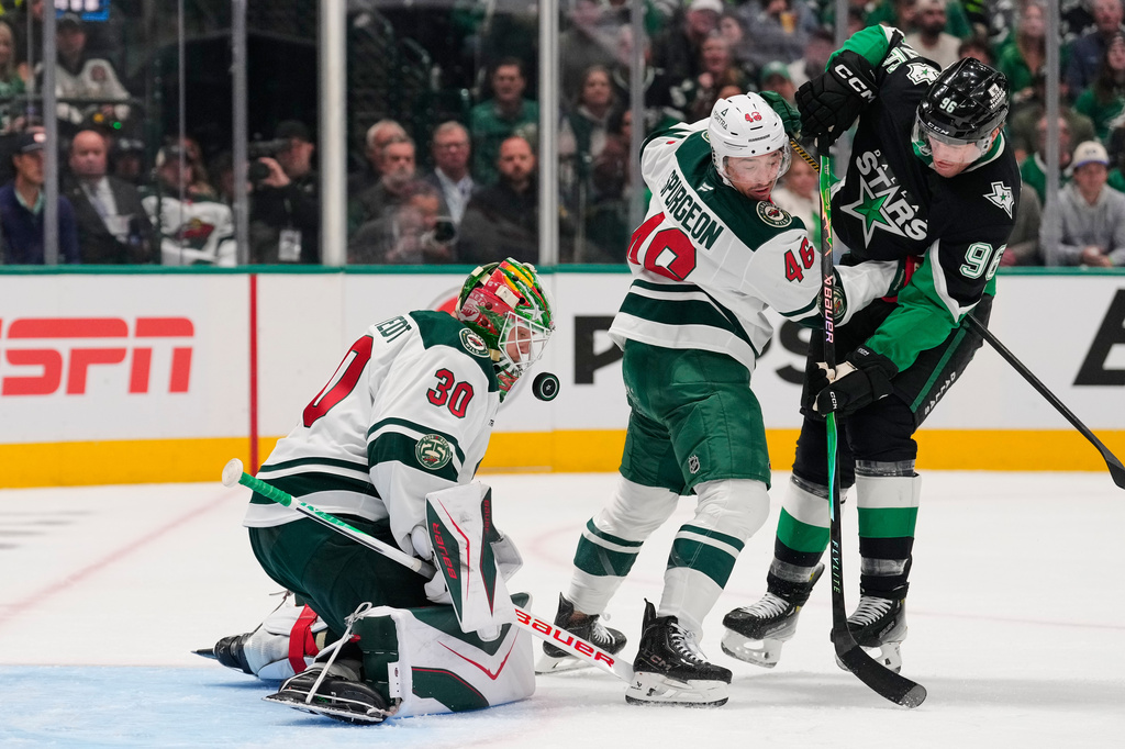 Minnesota Wild goaltender Jesper Wallstedt (30) defends against a shot from Dallas Stars' Mikko Rantanen (96) as Jared Spurgeon (46) helps defend in the first period of Game 2 of a first-round NHL Stanley Cup playoffs hockey series Monday, April 20, 2026, in Dallas. (AP Photo/Tony Gutierrez)un