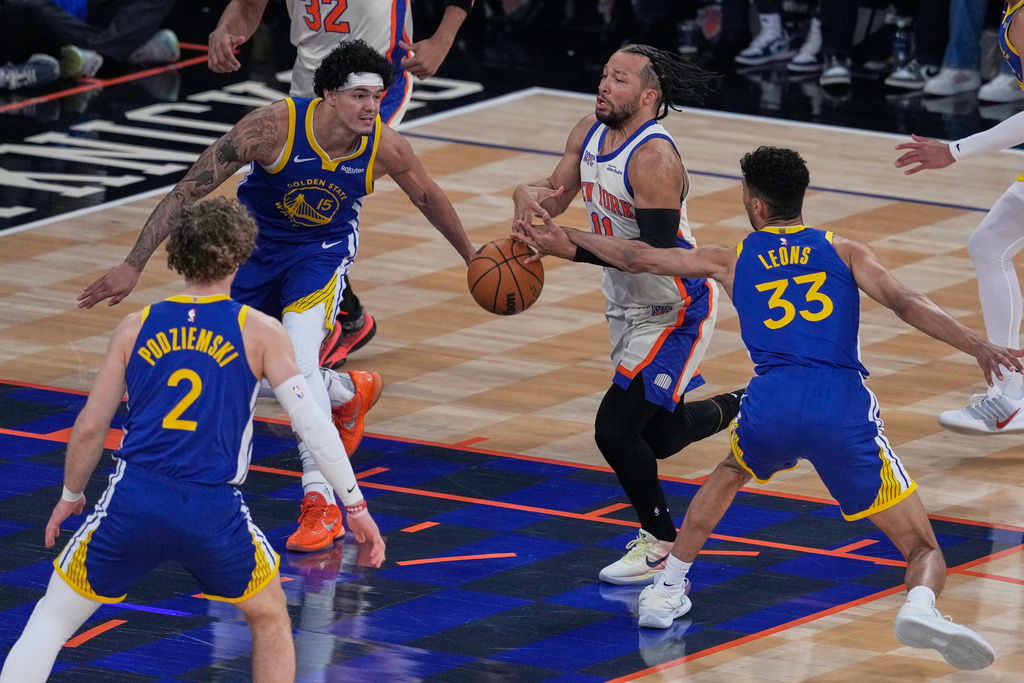 New York Knicks' Jalen Brunson, second from right, loses the ball as he drives to the basket during the first half of an NBA basketball game against the Golden State Warriors Sunday, March 15, 2026, in New York. (AP Photo/Seth Wenig)