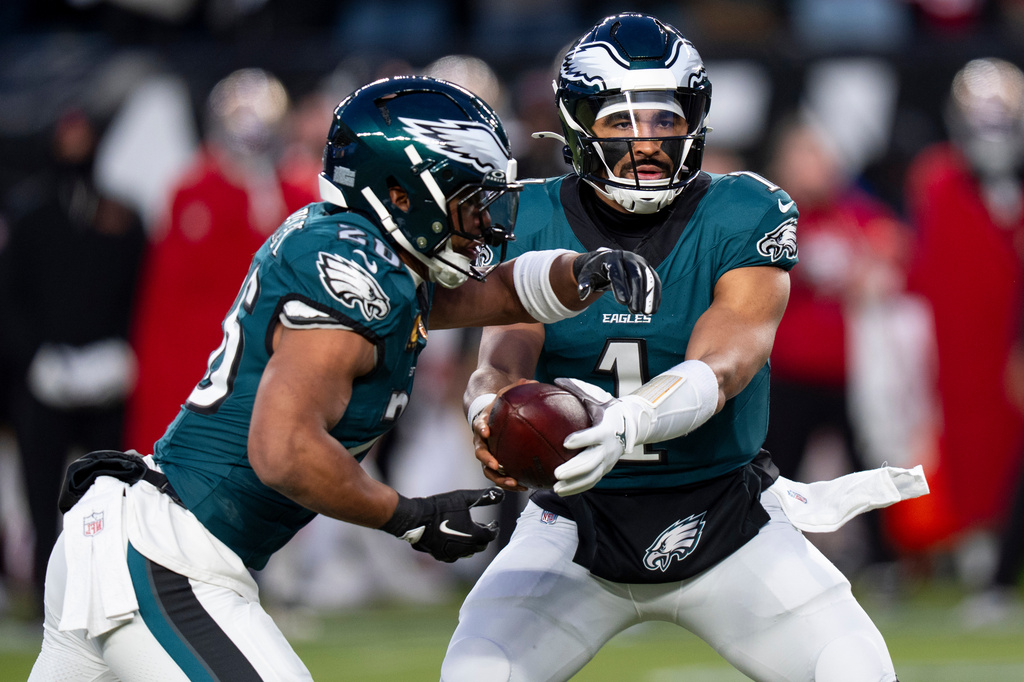 FILE - Philadelphia Eagles quarterback Jalen Hurts, right, hands the ball off to running back Saquon Barkley, left, during an NFL wild-card playoff football game against the San Francisco 49ers, Jan. 11, 2026, in Philadelphia. (AP Photo/Chris Szagola, File)