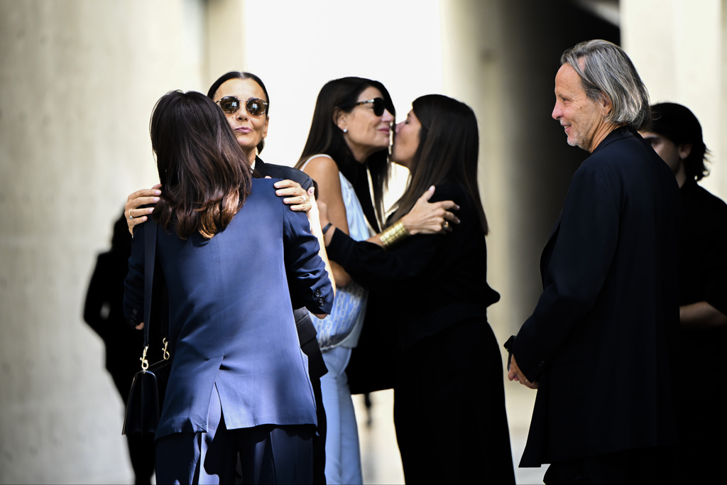 Mourners for fashion designer Giorgio Armani, who is lying in state at the Armani/Teatro in Milan, northern Italy, exchange condolences, Saturday, Sept. 6, 2025. (AP Photo/Nicola Marfisi)