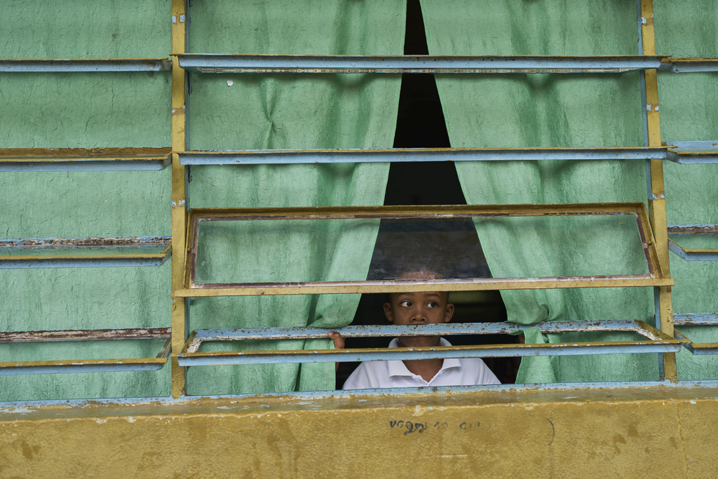 A youth peers from a school window in La Sierra, Venezuela, Thursday, June 26, 2025. (AP Photo/Ariana Cubillos)