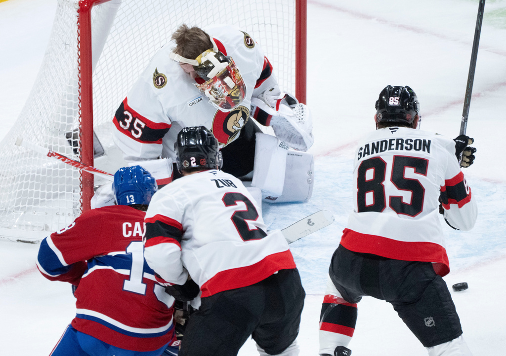 Ottawa Senators goaltender Linus Ullmark (35) loses his mask after being hit by the puck as Montreal Canadiens' Cole Caufield (13), Ottawa Senators' Artem Zub (2) and Jake Sanderson (85) look for the rebound during the first period of an NHL hockey game in Montreal, Saturday, Nov. 1, 2025. (Christinne Muschi/The Canadian Press via AP)