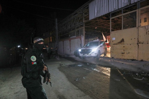 A gunman wearing the uniform of the al-Qassam Brigades, the military wing of Hamas, stands guard as Red Cross vehicles allegedly transporting coffins containing the bodies of four deceased hostages leave a warehouse for Israel, in Gaza City, Tuesday, Oct. 14, 2025. (AP Photo/Yousef Al Zanoun) A gunman wearing the uniform of the al-Qassam Brigades, the military wing of Hamas, stands guard as Red Cross vehicles allegedly transporting coffins containing the bodies of four deceased hostages leave a warehouse for Israel, in Gaza City, Tuesday, Oct. 14, 2025. (AP Photo/Yousef Al Zanoun)
