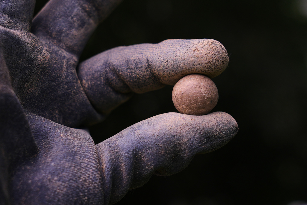 Calla Ruff, an intern from Carleton College, holds a musket ball that was removed from an archaeological dig at the site of the Battle of Bunker Hill, Monday, June 15, 2026, in Boston. (AP Photo/Charles Krupa)
