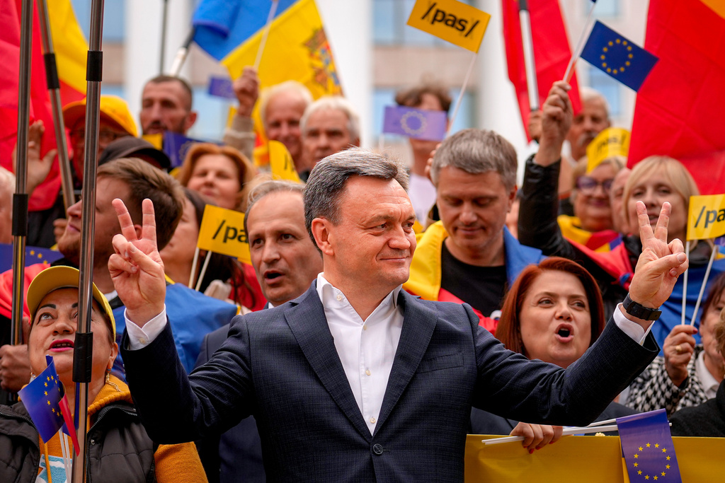 Moldova's Prime Minister Dorin Recean flashes the victory sign next to supporters during a pro-EU rally of the ruling Party of Action and Solidarity (PAS), in Chisinau, Moldova, Friday, Sept. 26, 2025, ahead of parliamentary elections taking place on Sept. 28. (AP Photo/Vadim Ghirda)