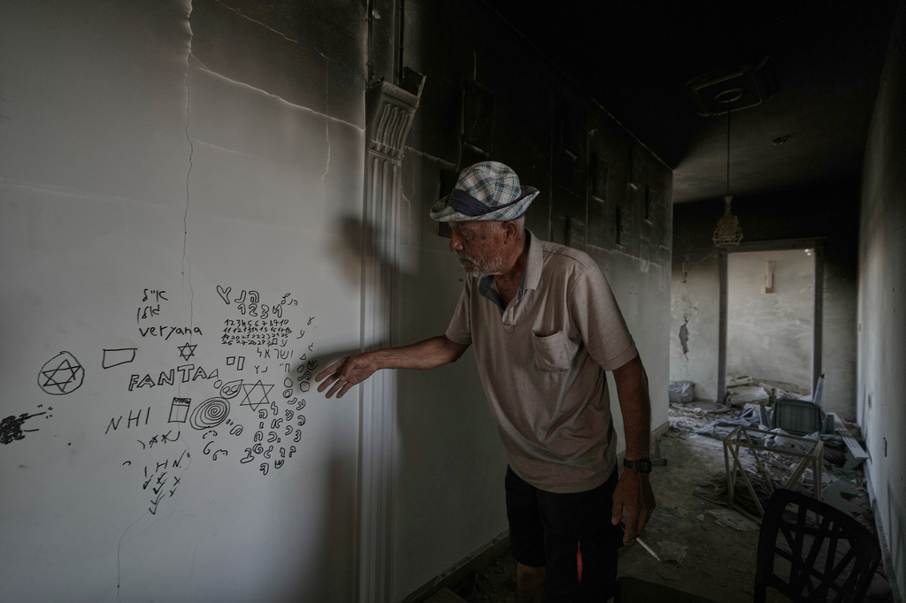 A Lebanese man points to Hebrew writing left by Israeli soldiers inside his destroyed home in the village of Zawtar al-Gharbieh, southern Lebanon, Wednesday, Aug. 5, 2026.(AP Photo/Mohammed Zaatari)