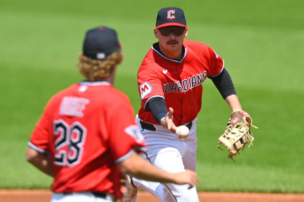 Cleveland Guardians first baseman Kyle Manzardo, right, tosses the ball to pitcher Tanner Bibee in the second inning of a baseball game against the Houston Astros in Cleveland, Wednesday, April 22, 2026. (AP Photo/David Richard)