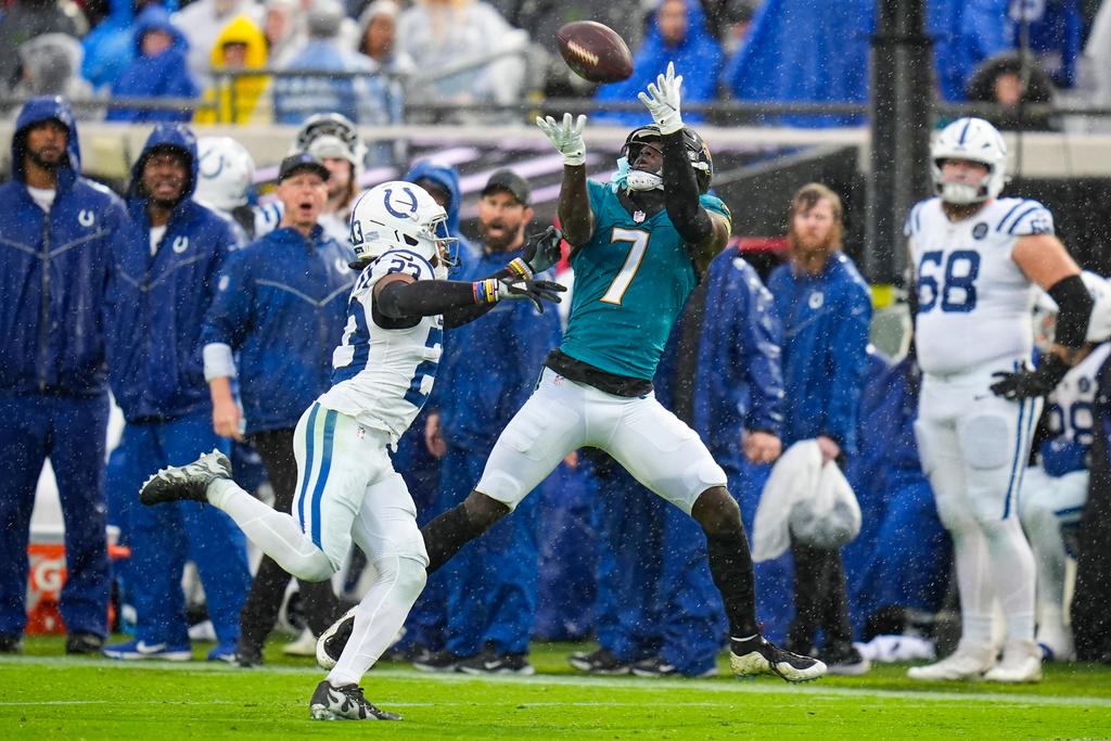 Jacksonville Jaguars wide receiver Brian Thomas Jr. (7) makes a catch over Indianapolis Colts cornerback Kenny Moore II (23) during the second half of an NFL football game, Sunday, Dec. 7, 2025, in Jacksonville, Fla. (AP Photo/John Raoux)