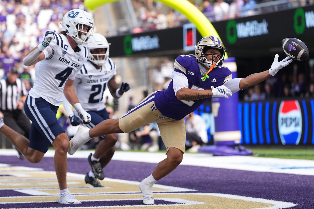 Washington wide receiver Dezmen Roebuck (2) can't bring in a pass in the end zone against Utah State safety Brevin Hamblin (4) during the first half of an NCAA college football game Saturday, Sept. 12, 2026, in Seattle. (AP Photo/Lindsey Wasson)