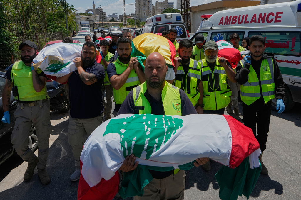 Mourners and paramedics carry the bodies of family members killed on Wednesday when their car was struck in an Israeli airstrike on a highway as they fled their village, during a funeral procession in the southern port city of Tyre, Lebanon, Friday, May 29, 2026. (AP Photo/Mohammed Zaatari)