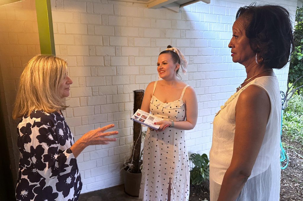 Laura Kajfez, left, speaks with Casey Clowes, center and Sandra Kennedy, candidates for the Salt River Project governing board, outside her home in Tempe, Ariz., on Wednesday, April 1, 2026. (AP Photo/Jonathan J. Cooper)