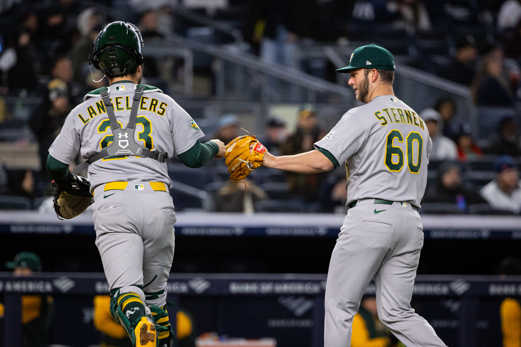 Athletics catcher Shea Langeliers (23) and Athletics pitcher Justin Sterner (60) bump fists during the sixth inning of a baseball game against the New York Yankees, Tuesday, April 7, 2026, in New York. (AP Photo/Angelina Katsanis)