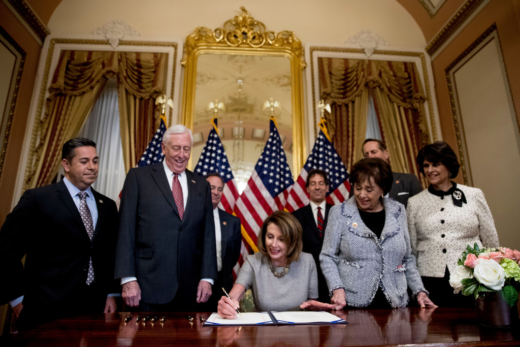 FILE - House Speaker Nancy Pelosi of Calif., center, accompanied by from left, Rep. Ben Ray Lujan, D-N.M., House Majority Leader Steny Hoyer of Md., Rep. Nita Lowey, D-N.Y, Rep. Lucille Roybal-Allard, D-Calif., and others, signs a deal to reopen the government on Capitol Hill in Washington, Jan. 25, 2019. (AP Photo/Andrew Harnik, File)
