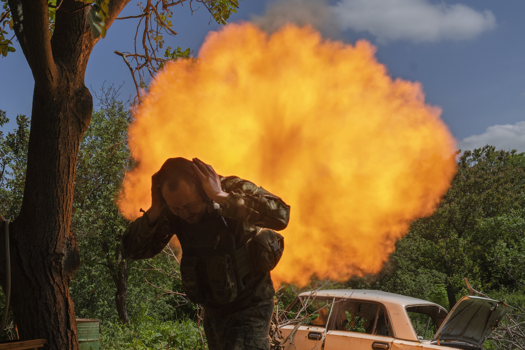 FILE - A Ukrainian soldier covers his ears while firing a mortar at Russian positions on the frontline near Bakhmut, Donetsk region, Ukraine, May 29, 2023. (AP Photo/Efrem Lukatsky, File)