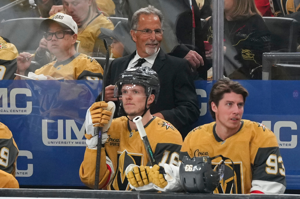 Vegas Golden Knights head coach John Tortorella, center top, looks on during the first period of an NHL hockey game against the Vancouver Canucks, Monday, March 30, 2026, in Las Vegas. (AP Photo/Candice Ward)