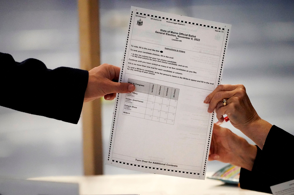 FILE - A ballot is handed to a voter, Nov. 8, 2022, in Lewiston, Maine. (AP Photo/Robert F. Bukaty, File)