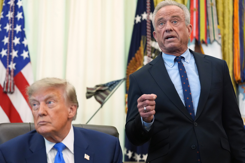 Health and Human Services Secretary Robert F. Kennedy Jr. speaks as President Donald Trump listens during a meeting to sign an executive order about vaccines, Monday, Aug. 10, 2026, in the Oval Office of the White House in Washington. (AP Photo/Jacquelyn Martin)