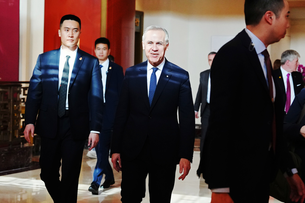 Canada's Prime Minister Mark Carney, center, walks through a hotel lobby in Beijing, China Thursday, Jan. 15, 2026. (Sean Kilpatrick/The Canadian Press via AP)