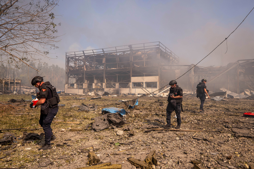 Police officers inspect the area, after a Russian attack struck a warehouse, followed by an explosion, in the village of Myla, Kyiv region, Ukraine, Saturday, Aug. 29, 2026. (AP Photo/Dan Bashakov)