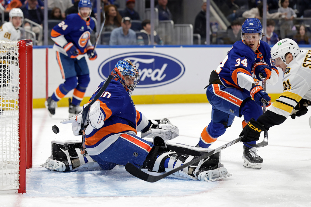 Boston Bruins center Alex Steeves, right, scores a goal past New York Islanders goaltender Ilya Sorokin in the first period of an NHL hockey game, Wednesday, Nov. 26, 2025, in Elmont, N.Y. (AP Photo/Adam Hunger)