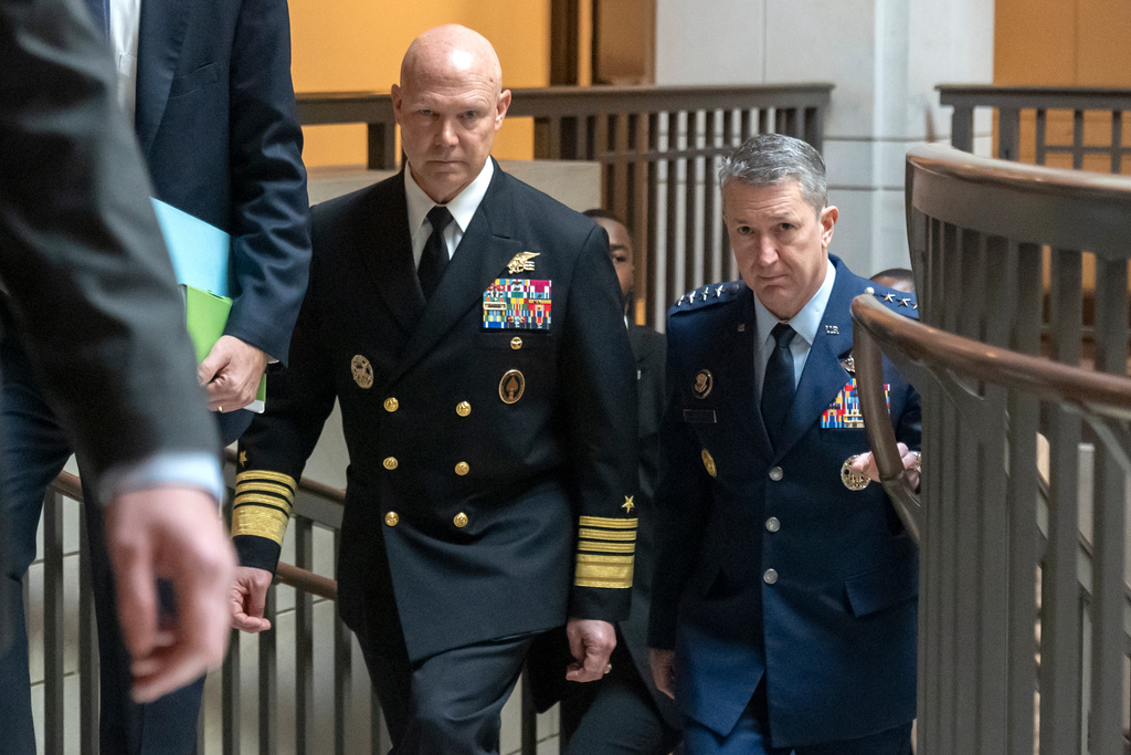 U.S. Navy Adm. Frank M. Bradley, accompanied by Gen. Dan Caine, chairman of the Joint Chiefs of Staff, right, walks to a meeting with senators on Capitol Hill, Thursday, Dec. 4, 2025, in Washington. (AP Photo/Mark Schiefelbein)