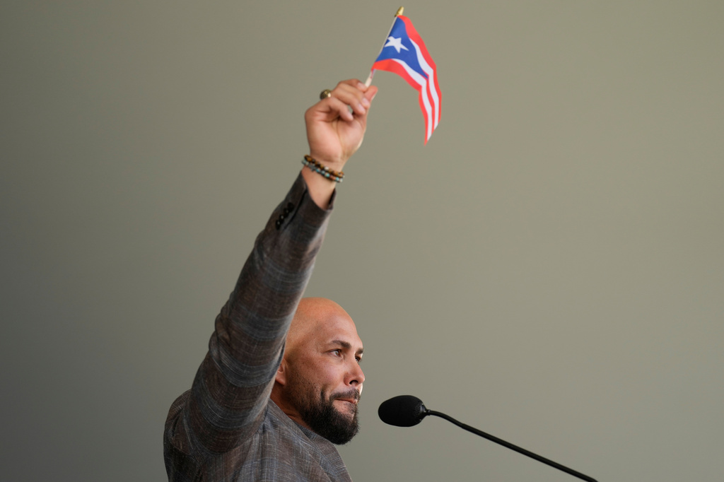 Carlos Beltran waves a Puerto Rican flag while speaking during the Baseball Hall of Fame induction ceremony in Cooperstown, N.Y., Sunday, July 26, 2026. (AP Photo/Seth Wenig)