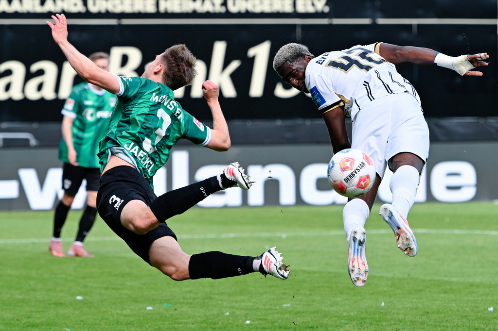 Elversberg's David Mokwa, right, and Preußen Münster's Paul Jaeckel fight for the ball during the Bundesliga 2 soccer match between SV Elversberg and SC Preußen Münster in Spiesen-Elversberg, Germany, Sunday May 17, 2026. (Uwe Anspach/dpa via AP)