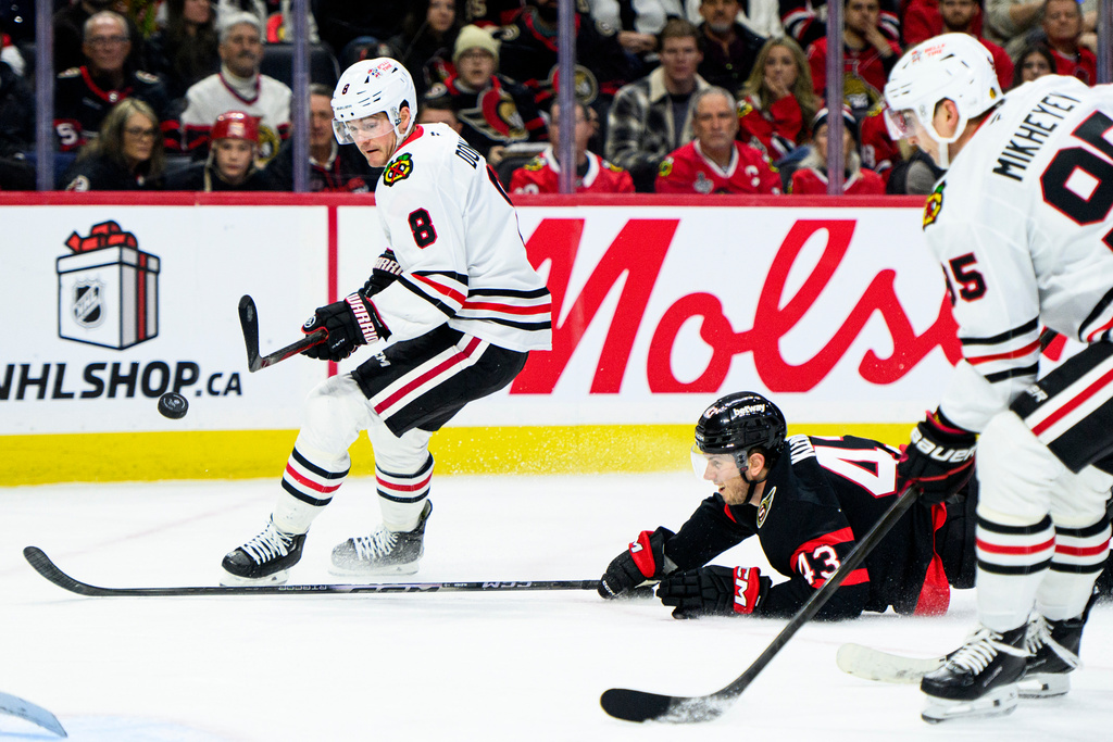 Chicago Blackhawks center Ryan Donato (8) shoots on net as Ottawa Senators defenseman Tyler Kleven (43) loses his balance during first-period NHL hockey game action in Ottawa, Ontario, Saturday, Dec. 20, 2025. (Spencer Colby/The Canadian Press via AP)