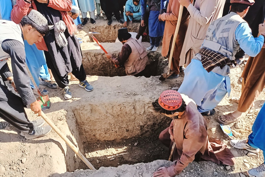 Locals dig graves for people killed in a cross-border airstrike by the Pakistani army in Afghanistan's eastern Paktika province, Saturday, Oct. 18, 2025. (AP Photo/Shafiqullah Mashaal)