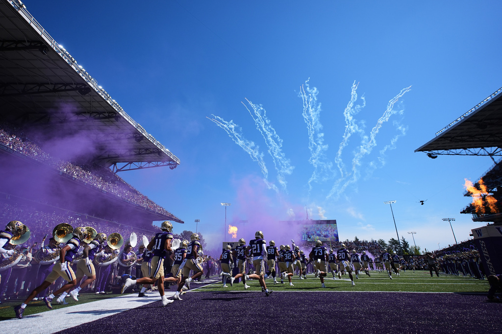 Washington runs out to the field before facing Washington State in an NCAA college football game, Sunday, Sept. 6, 2026, in Seattle. (AP Photo/Lindsey Wasson)