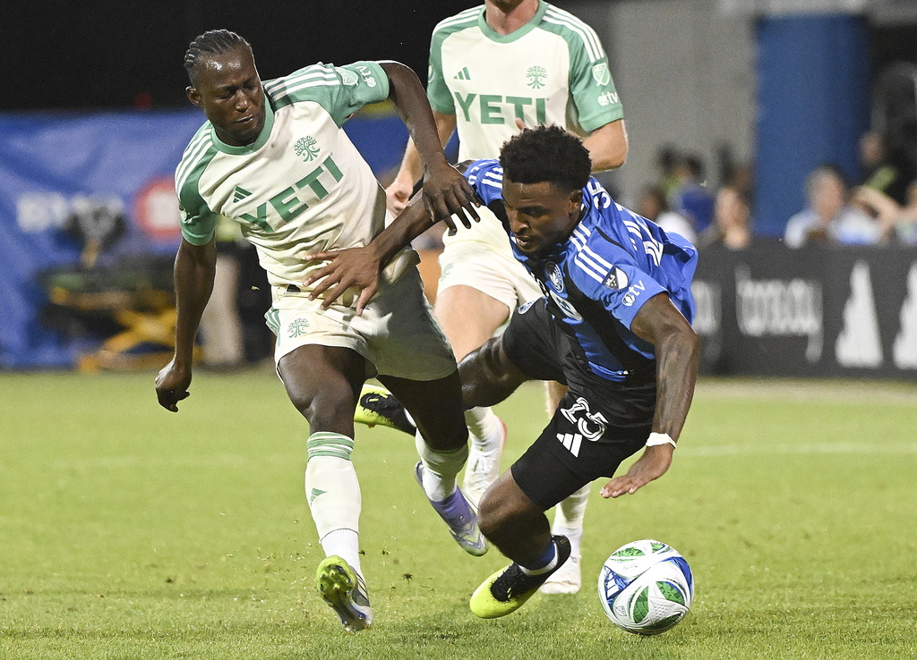 Austin FC's Osman Bukari, left, tackles CF Montreal's Dante Sealy (25) during the second half of an MLS soccer game in Montreal, Saturday, Aug. 23, 2025. (Graham Hughes/The Canadian Press via AP)