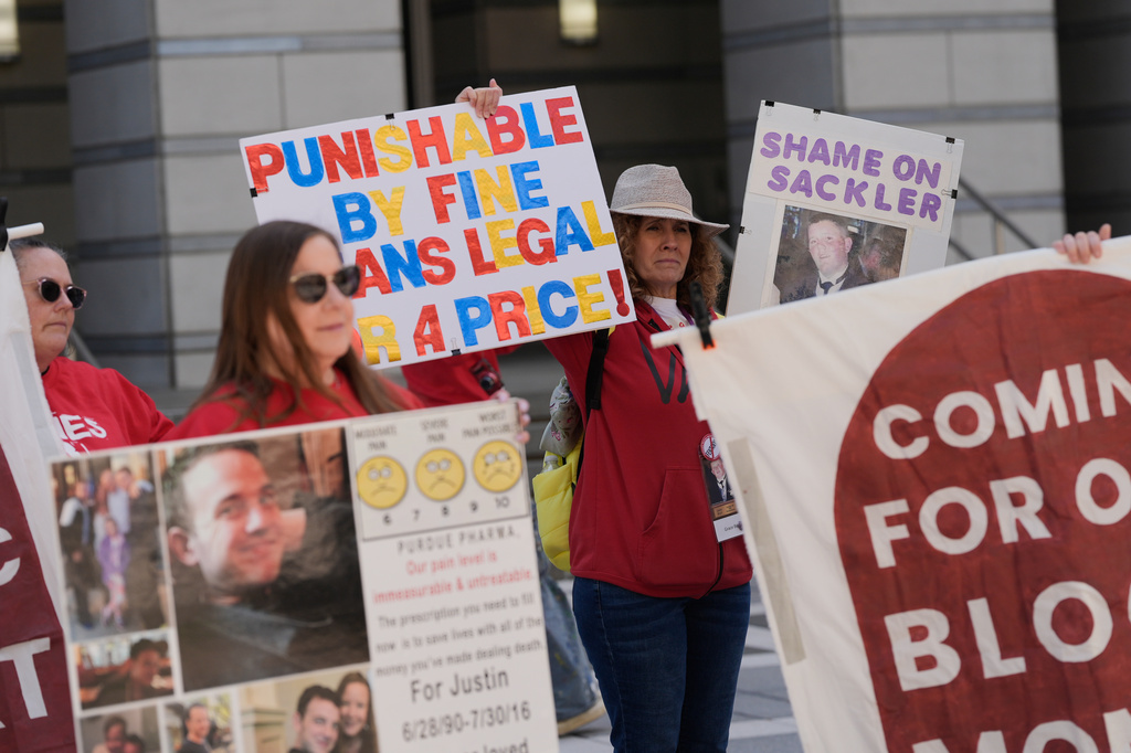 People rally outside a courthouse while a hearing for Purdue Pharma takes place inside in Newark, N.J., Tuesday, April 21, 2026. (AP Photo/Seth Wenig)