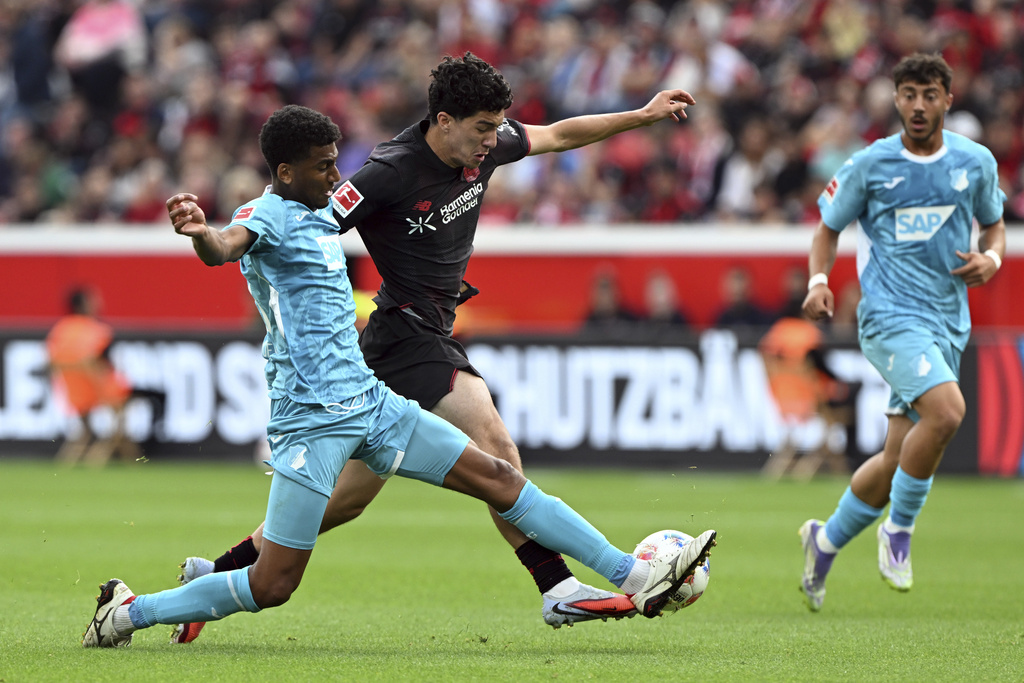 Leverkusen's Ibrahim Maza and Hoffenheim's Bernardo, left, fight for the ball during the German Bundesliga soccer match between Bayer Leverkusen and Hoffenheim at the BayArena in Leverkusen, Germany, Saturday Aug. 23, 2025. (Federico Gambarini/dpa via AP)