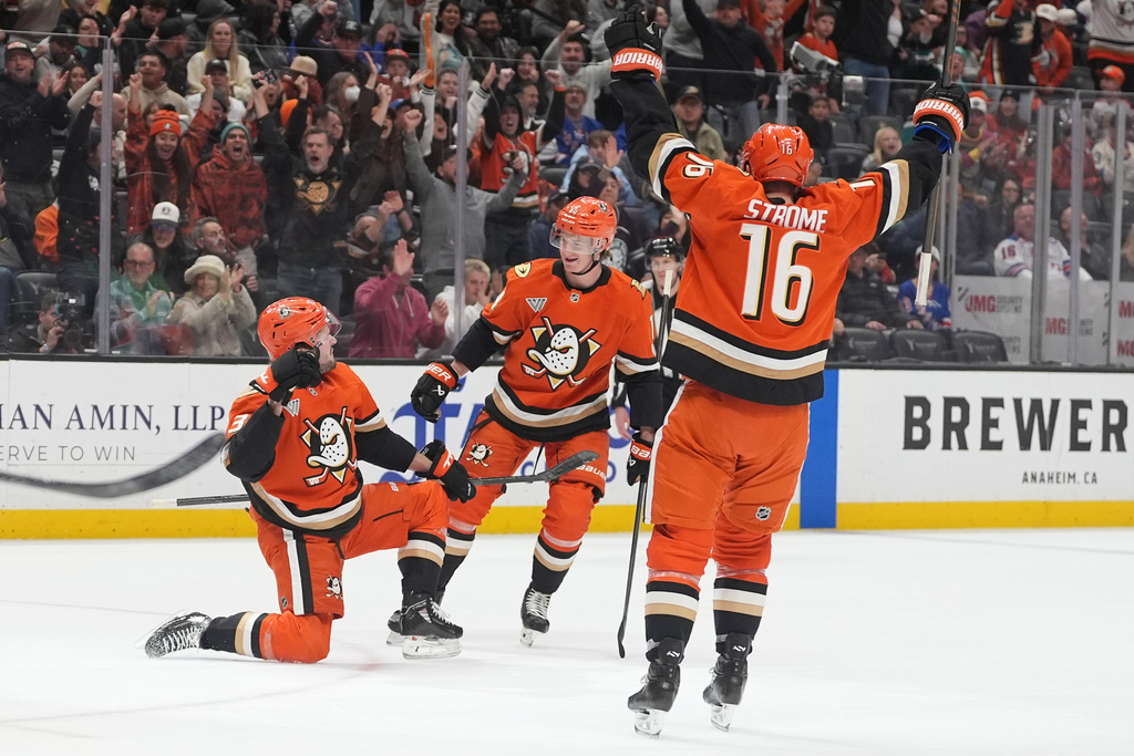 Anaheim Ducks center Mason McTavish, left, celebrates his goal with teammates defenseman Drew Helleson, center, and center Ryan Strome during the first period of an NHL hockey game against the New York Rangers Monday, Jan. 19, 2026, in Anaheim, Calif. (AP Photo/Gregory Bull)