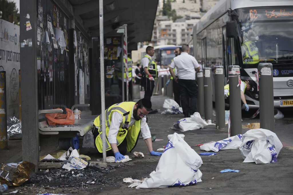 Israeli ZAKA rescue and recovery personnel clean bloodstains at the scene of a shooting attack carried out by two Palestinian gunmen, in which several people were killed and others injured at a bus stop in Jerusalem, Monday, Sept. 8, 2025. (AP Photo/Mahmoud Illean)